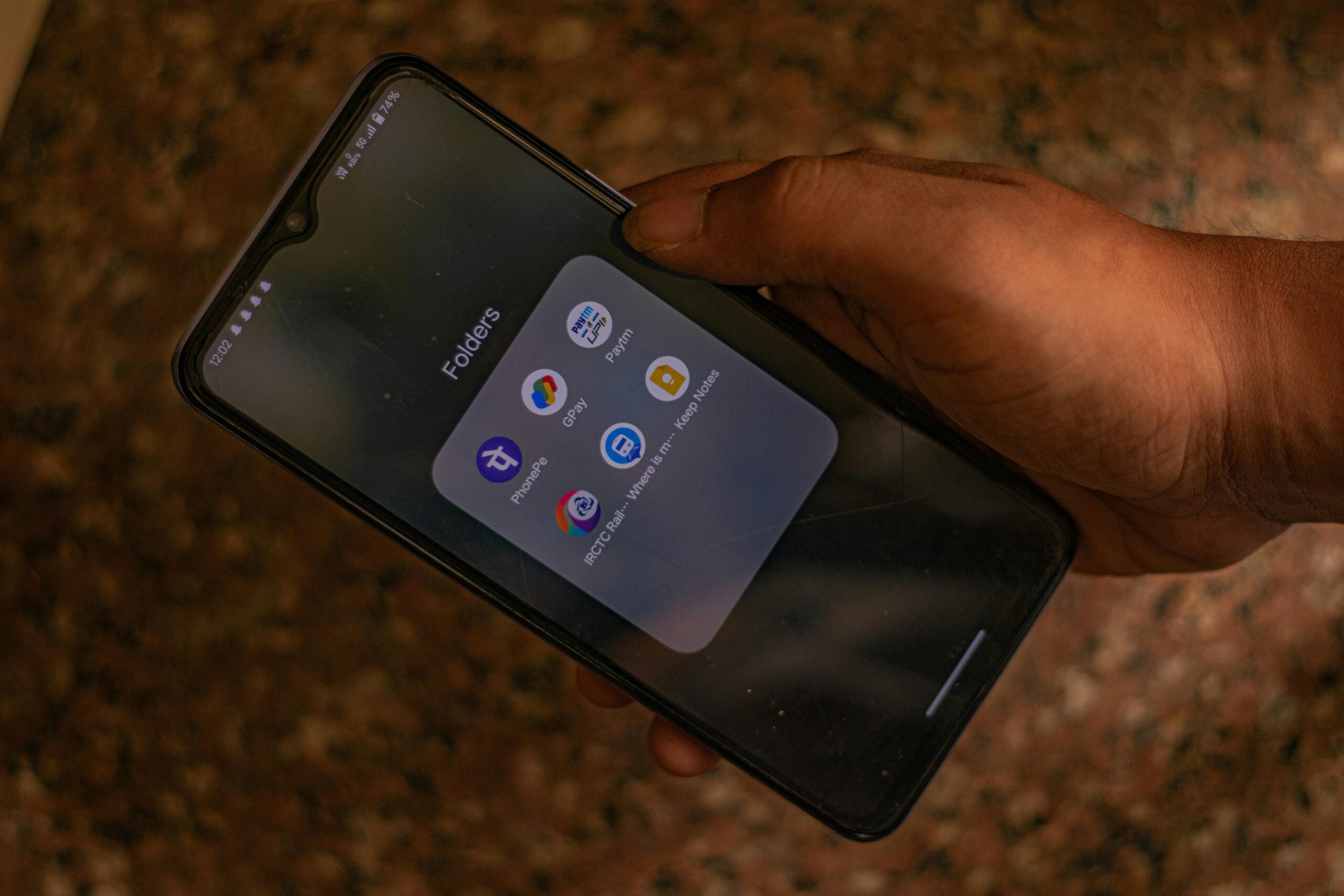 A hand holds a smartphone displaying popular payment apps for digital transactions. Best UPI Apps in India 2025